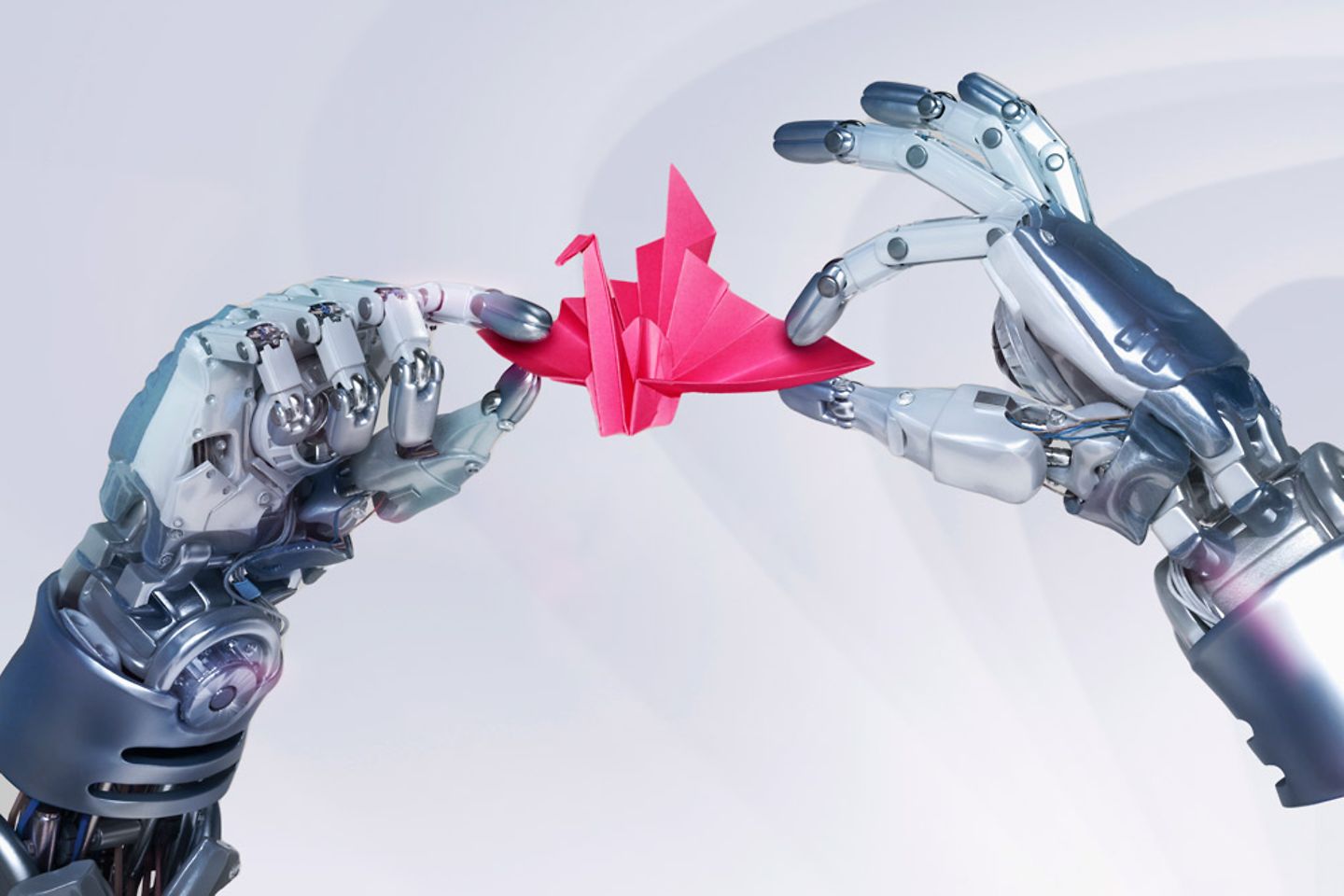 Zwei Roboterhände halten ein gefaltetes Papier.