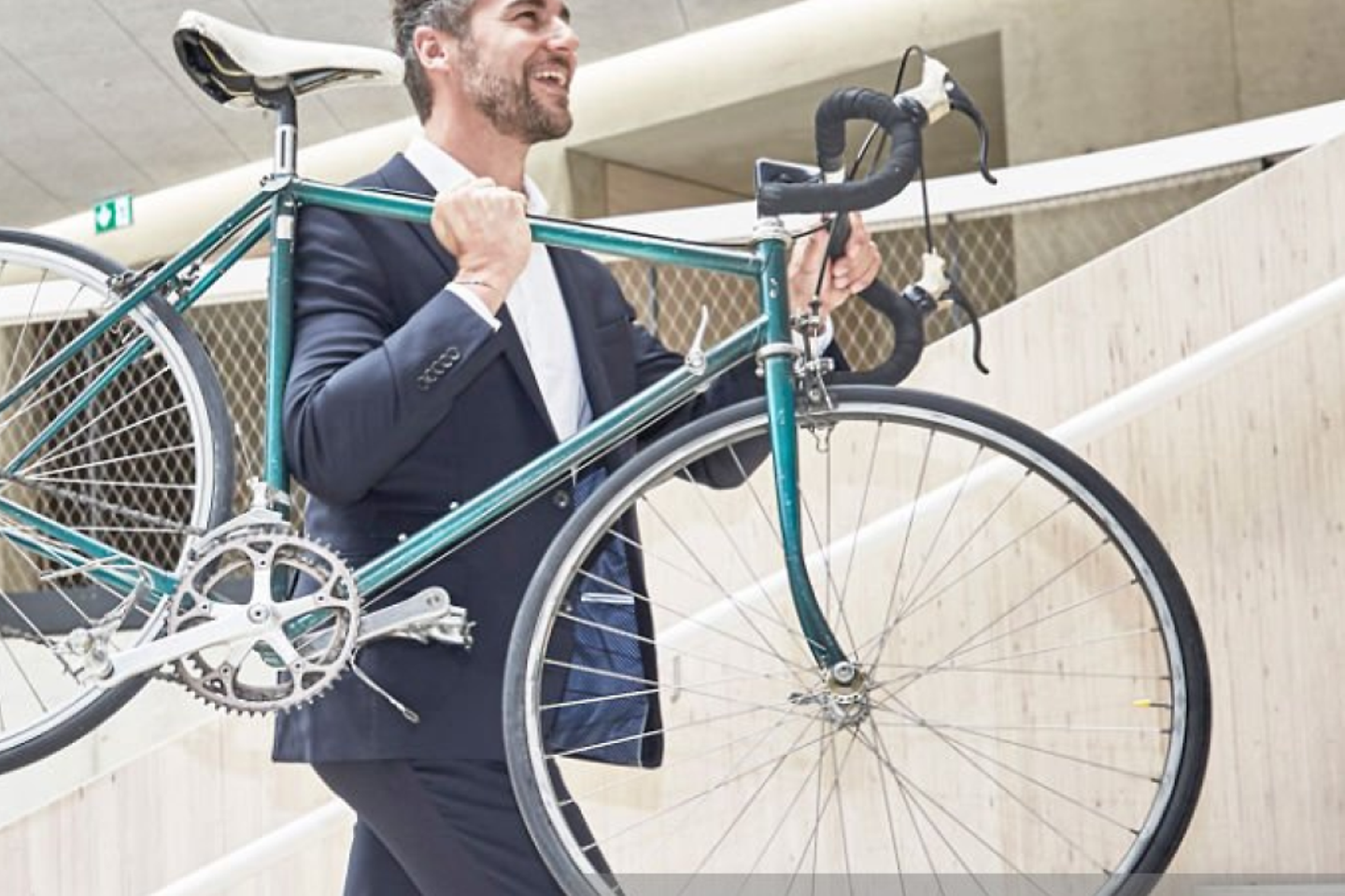 Businesssman carrying bicycle in modern office building