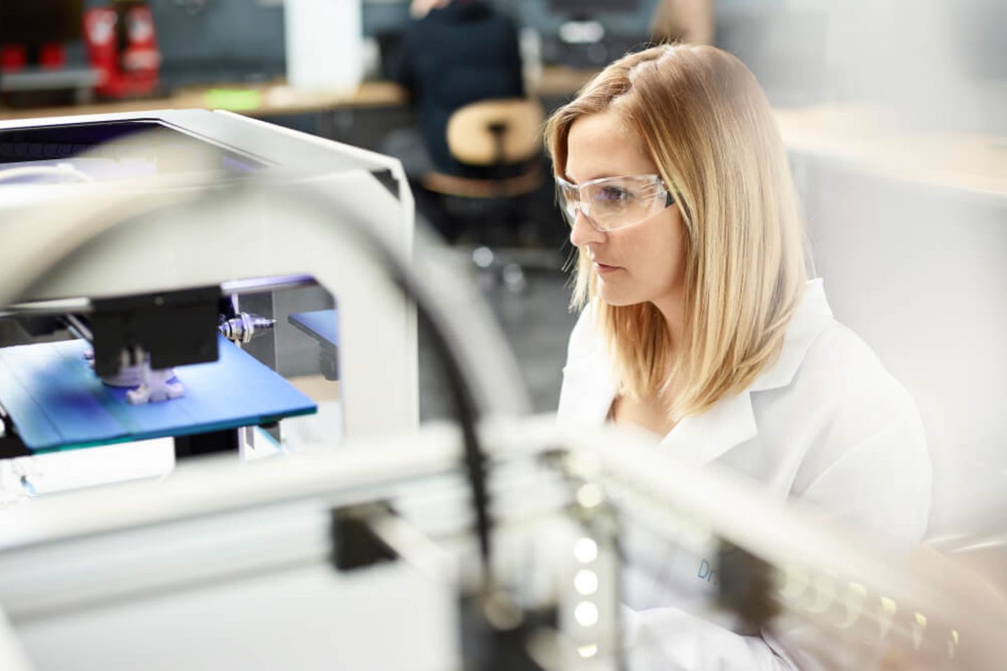 Female technician checking 3D printer