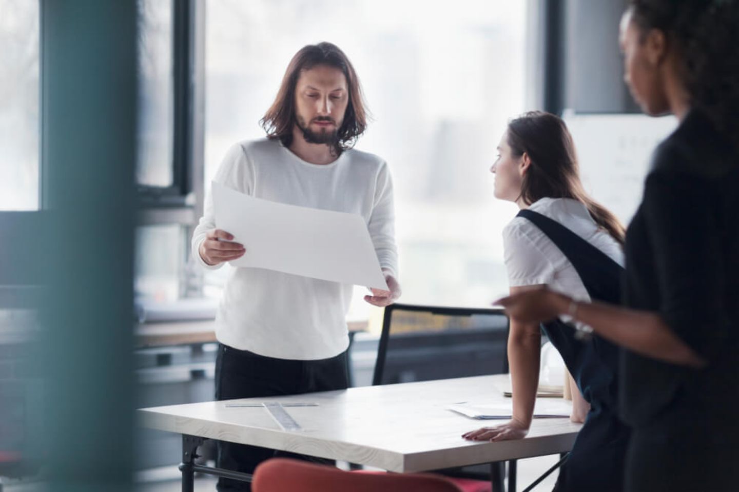 Colleagues review a document in an office meeting