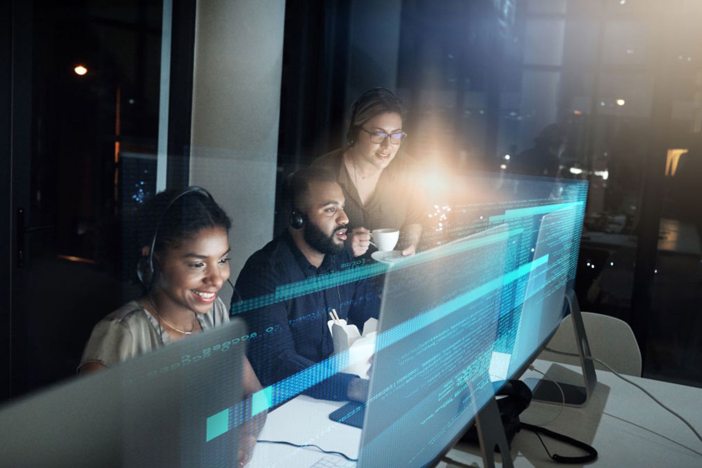 Team works with headsets in front of computer with blue virtual overlay