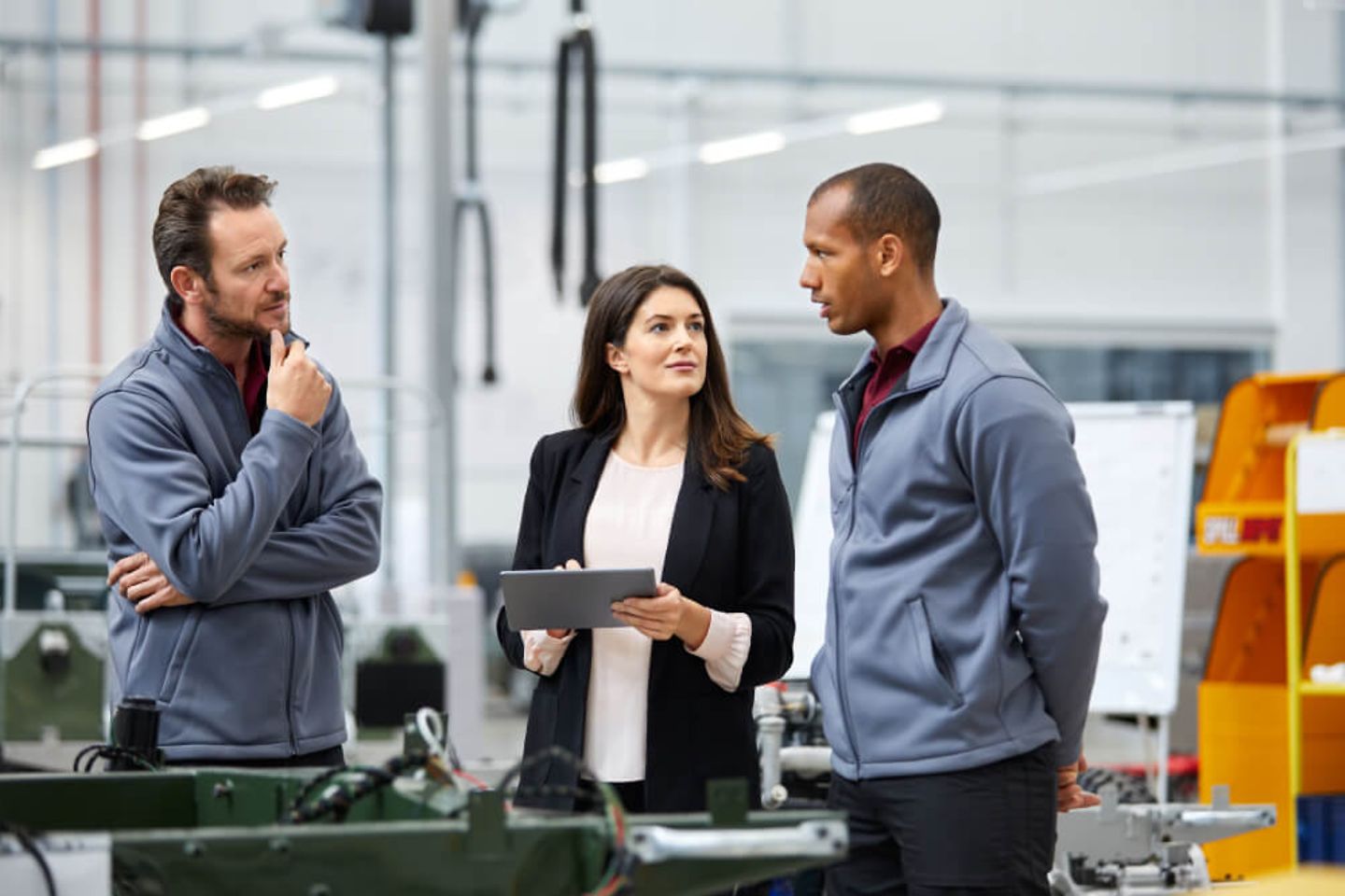 Automobilingenieur im Gespraech mit Kollegen in der Autofabrik