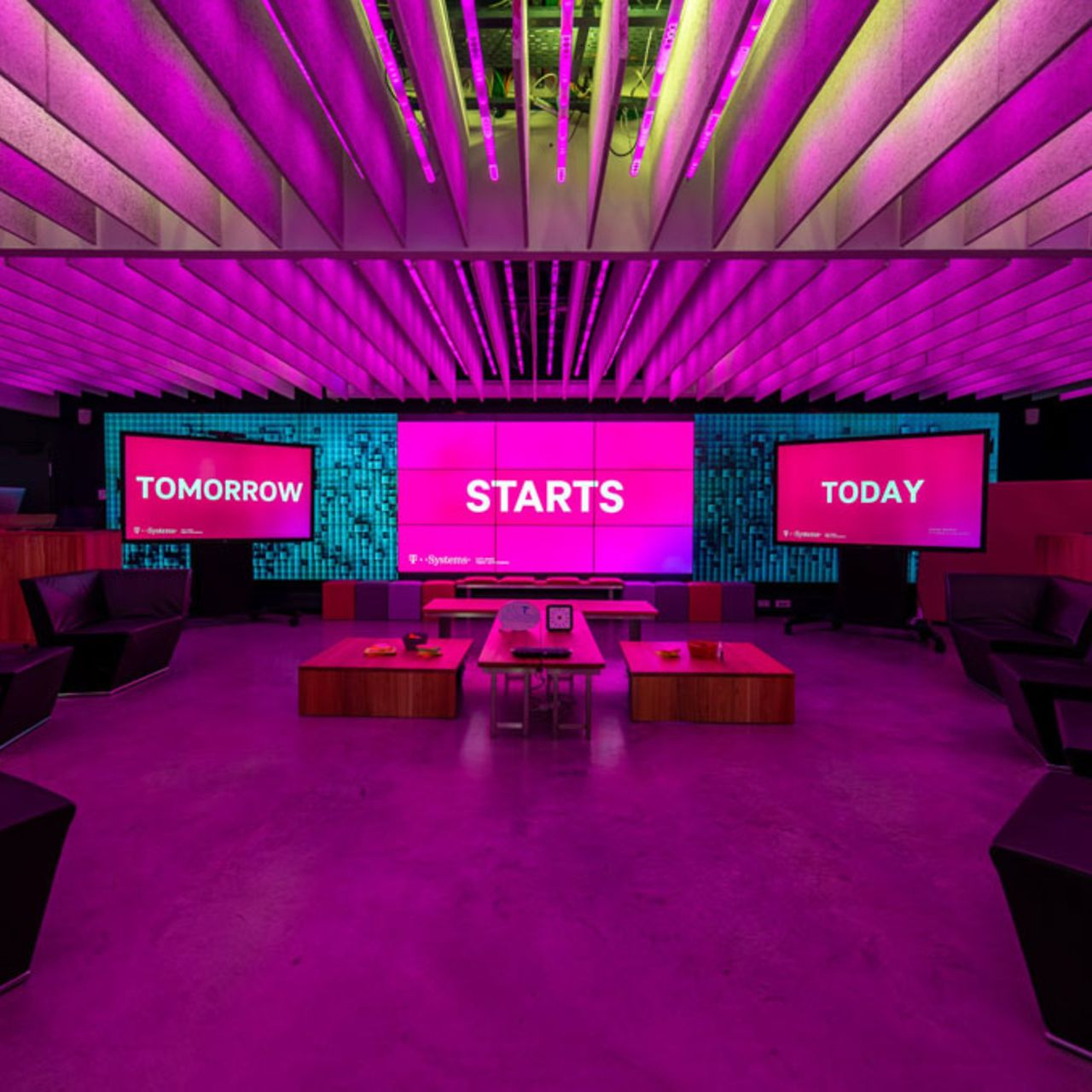 Innovation Center München mit Bildschirmen, Tischen und Stühlen