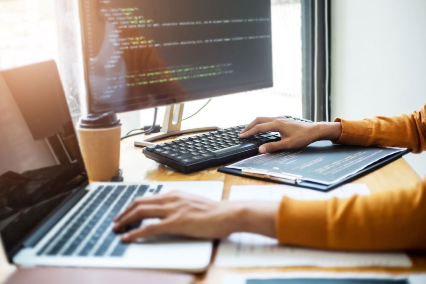 Women sitting in front of a computer and working with html codes