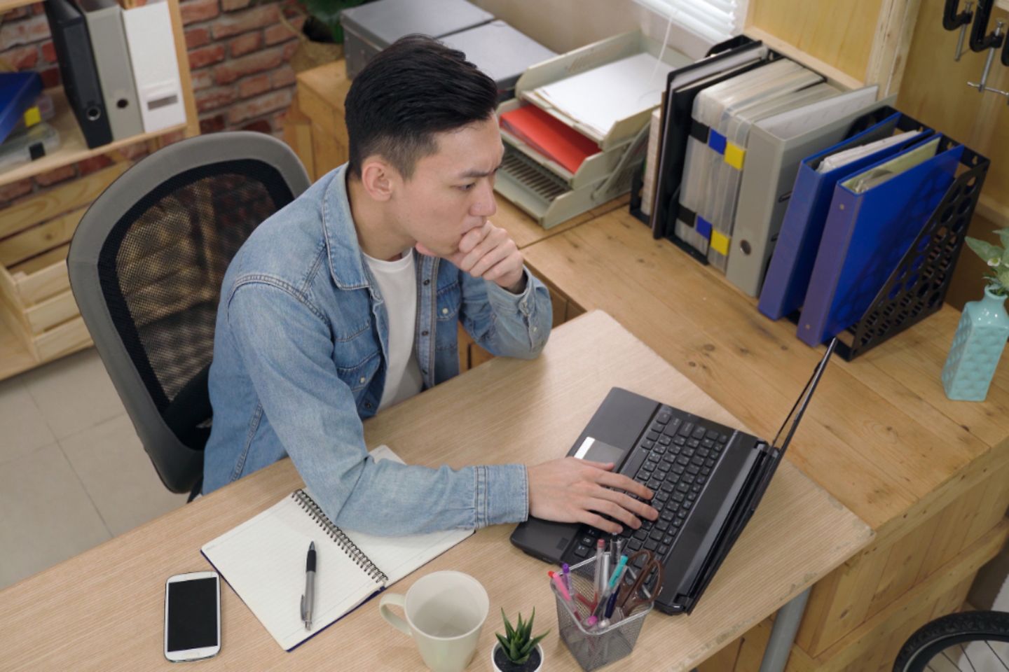 Man typing a proposal letter on the laptop in the office