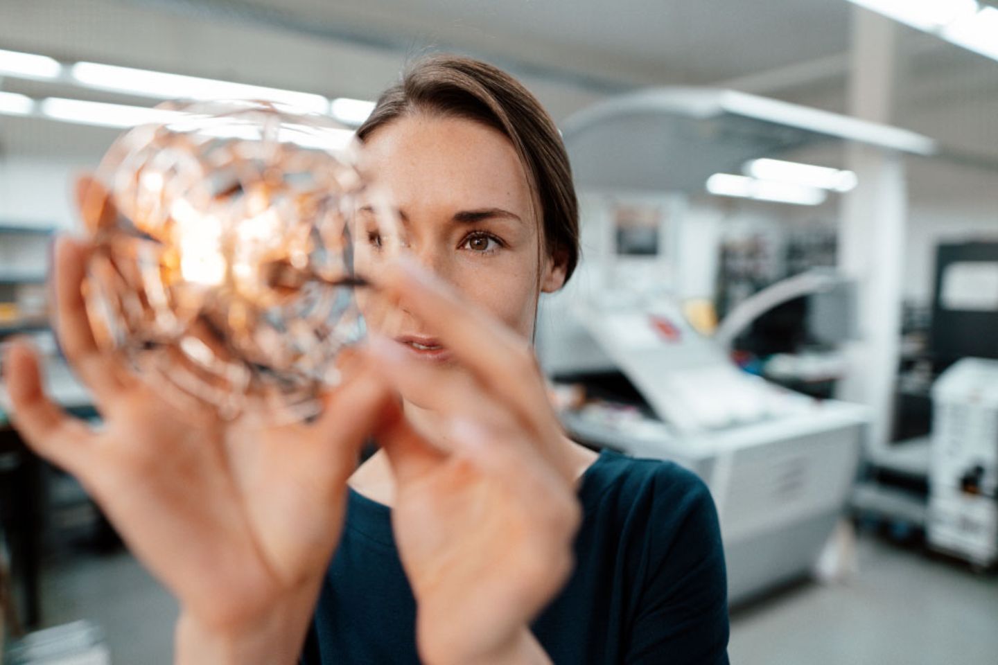 A woman inspects a light bulb