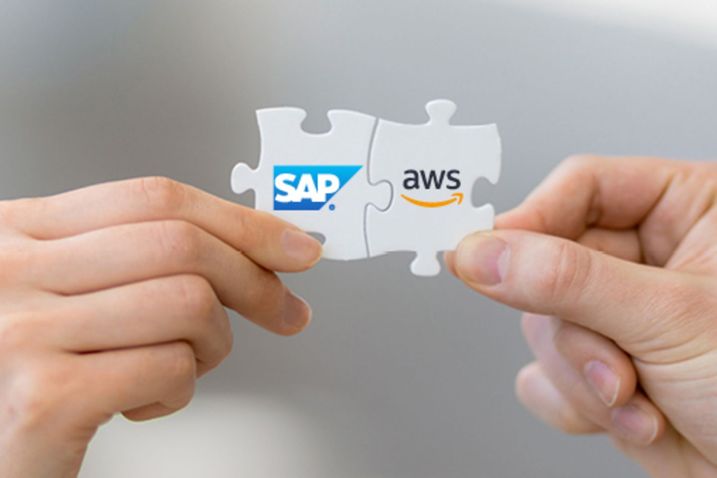 Hands hold puzzle pieces with SAP and AWS logos fitting together.