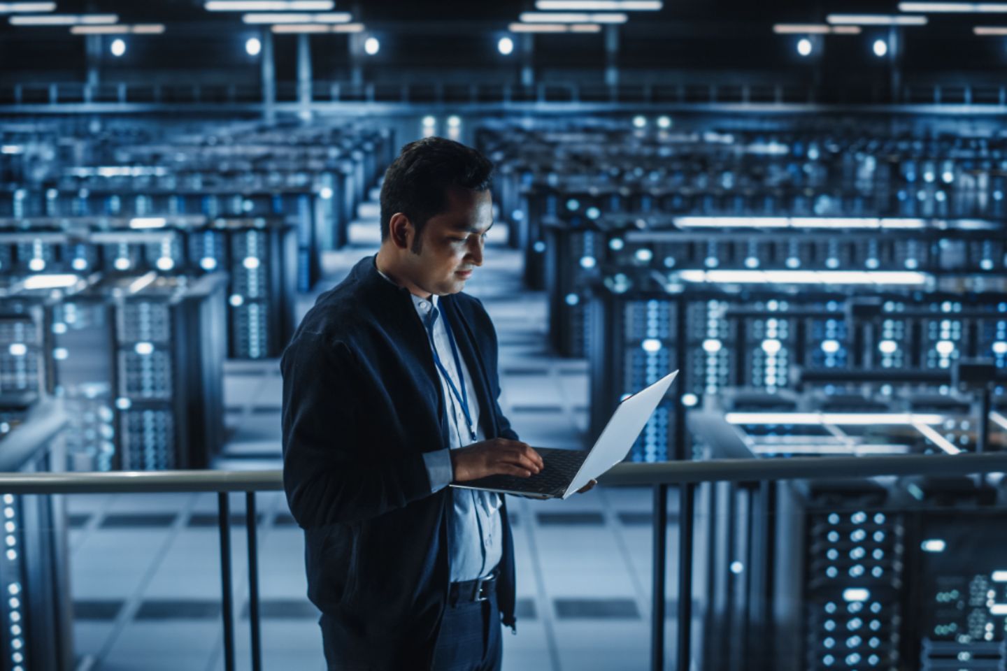 Portrait of male IT specialist using laptop in data centre