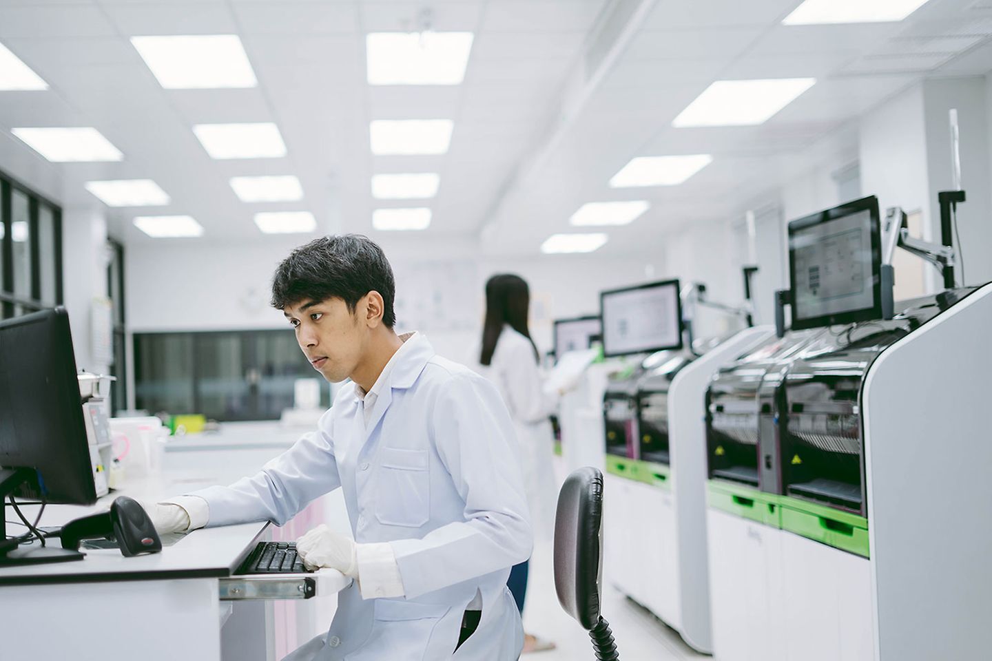 young male scientist looking results from automation blood analyzer report