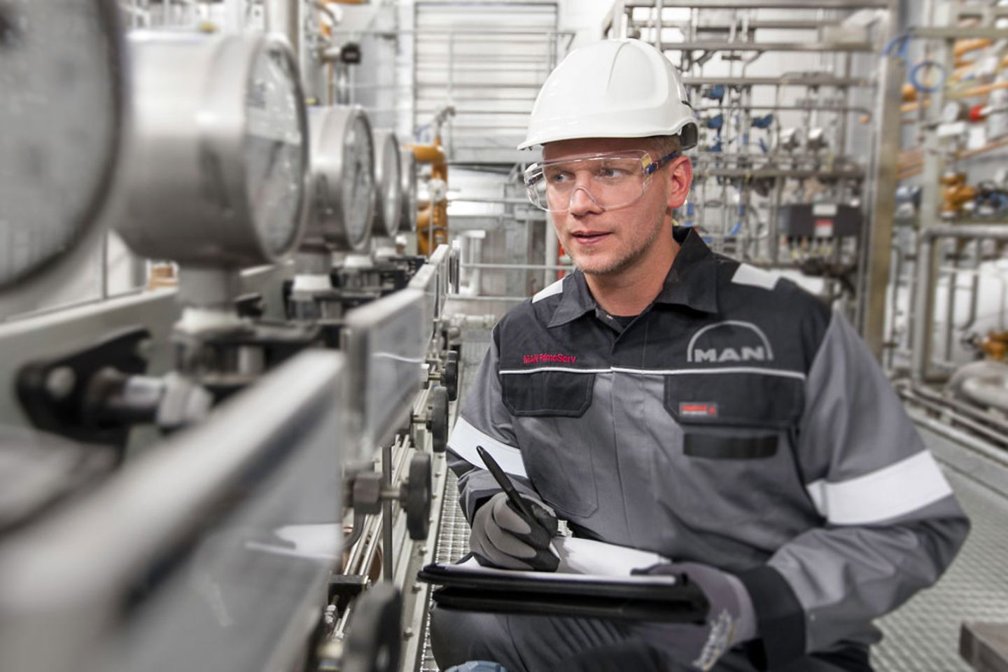 MAN Techniker prüft Werte in einer Fabrik