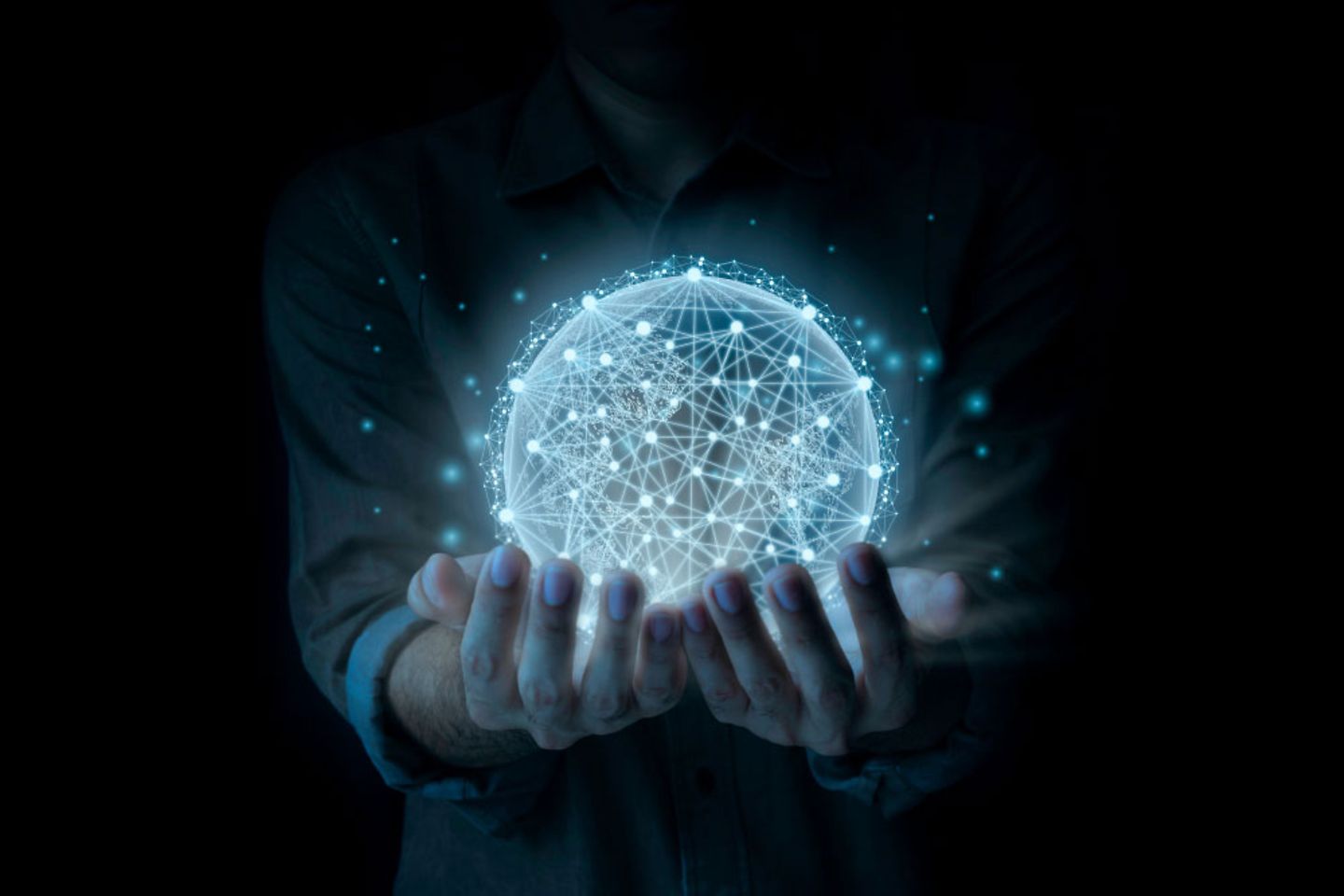 A man holds a luminous globe with network structure