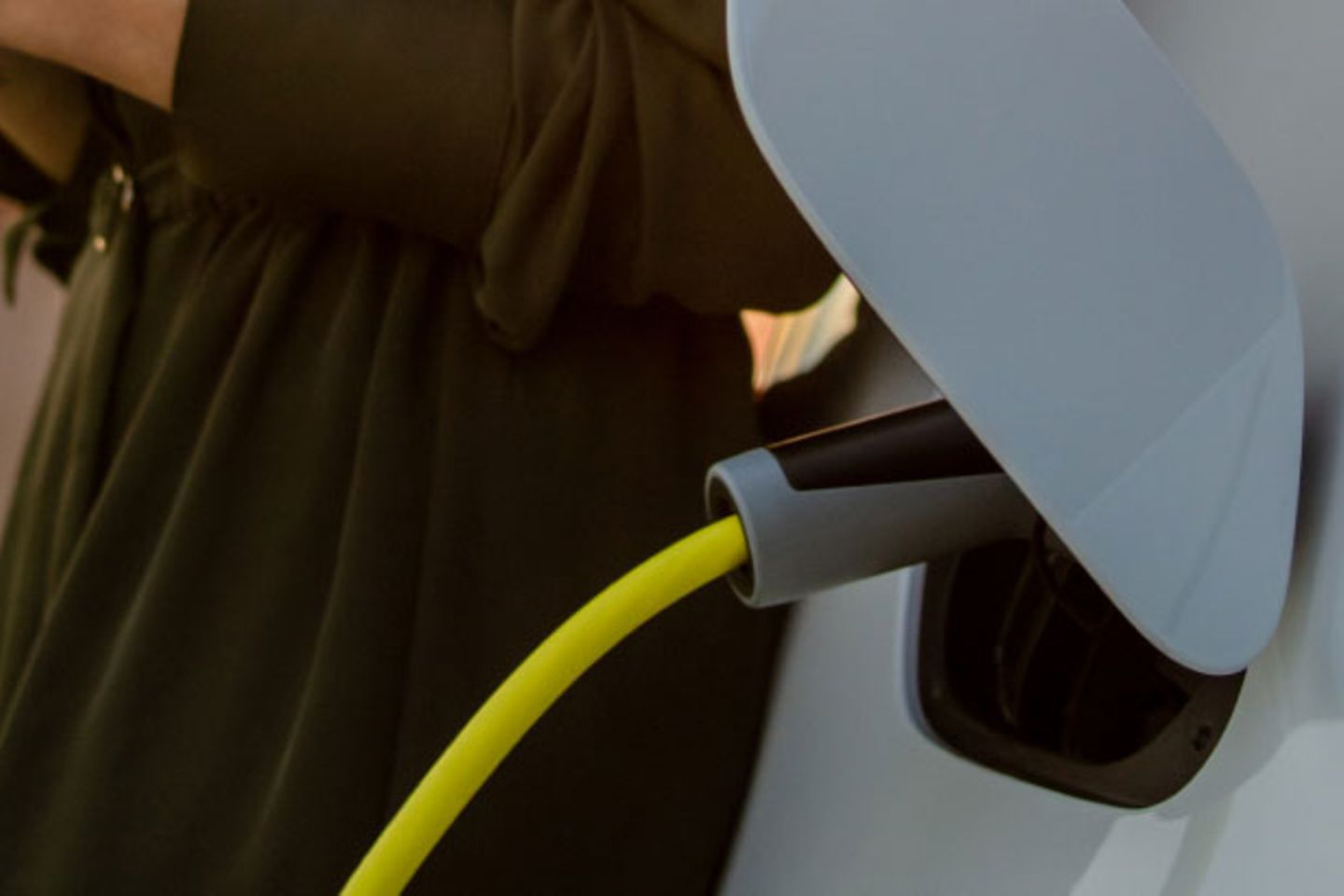 Women leaning on the car while Electric Car is Charging