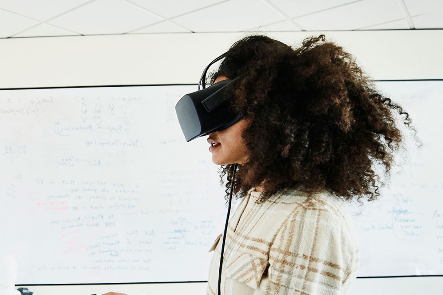 Frau mit VR-Brille steht vor einem Whiteboard