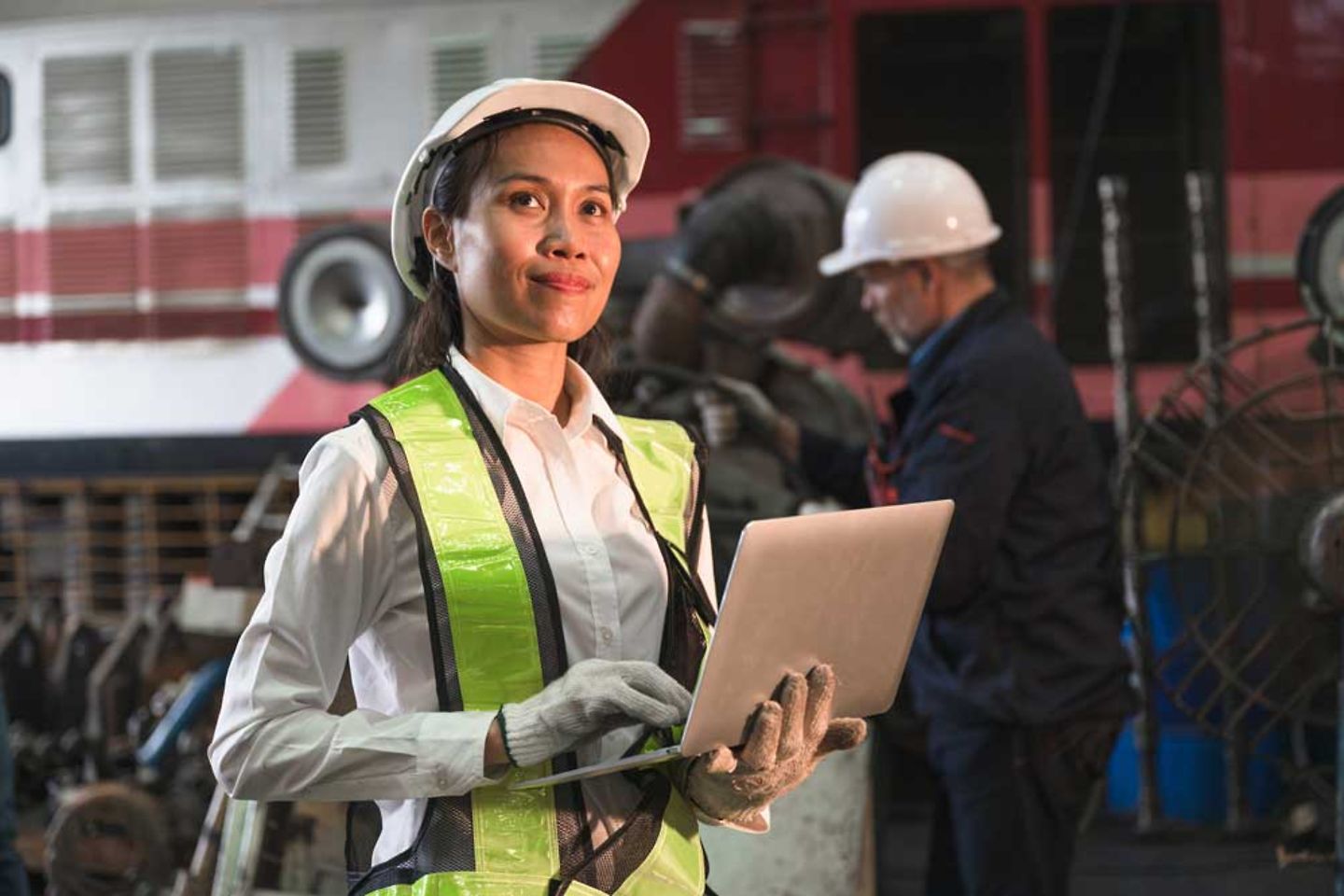 Machinist using digital laptop in factory