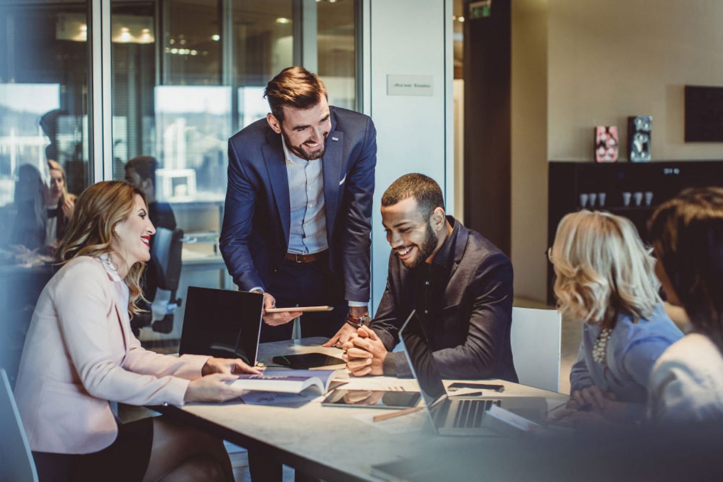 Menschen in einem Büro, die zusammen diskutieren und am Laptop arbeiten