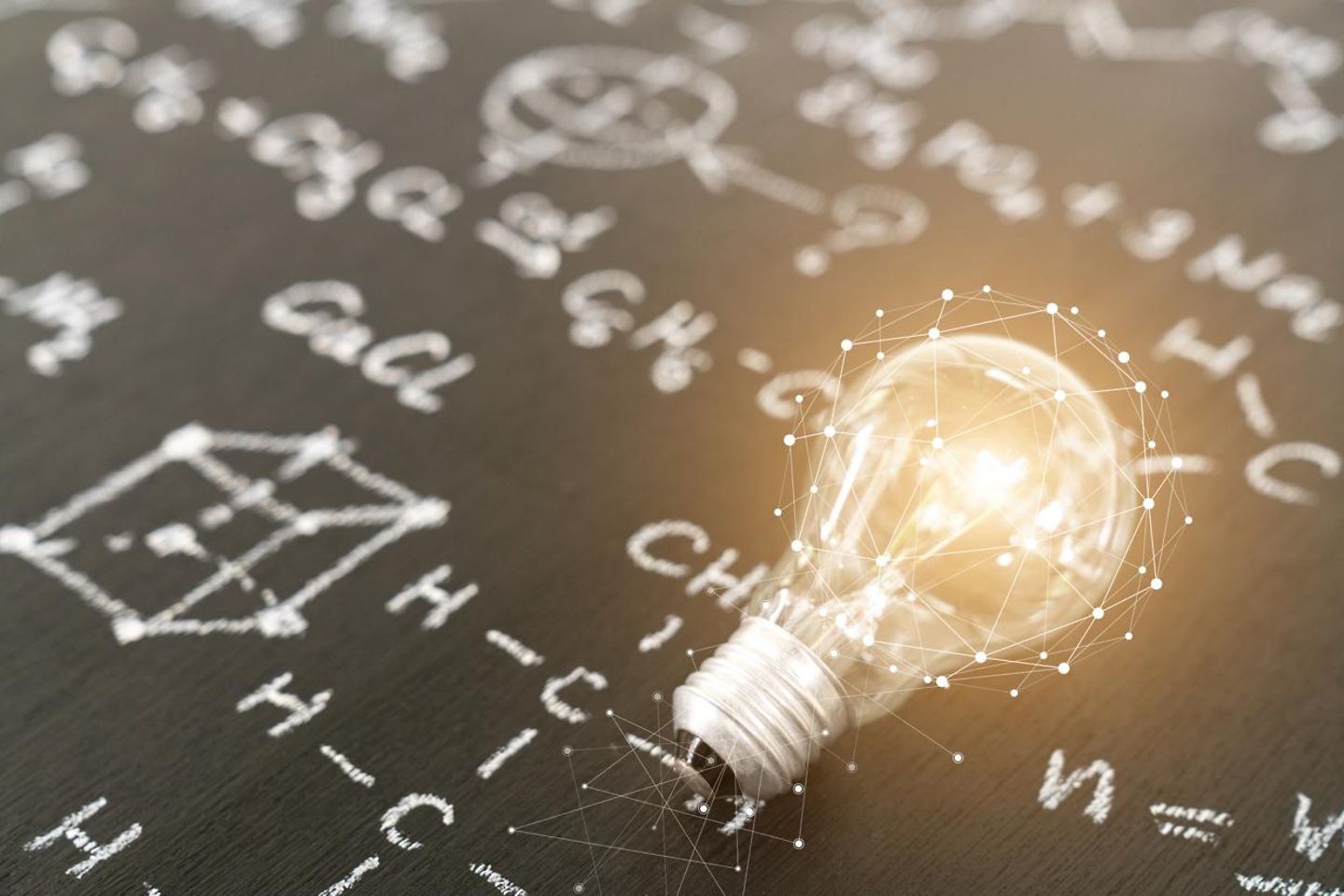 Light bulb on blackboard with formulas