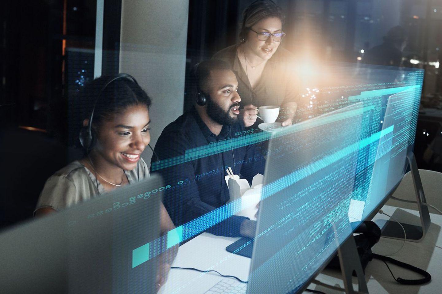 Team works with headsets in front of computer with blue virtual overlay