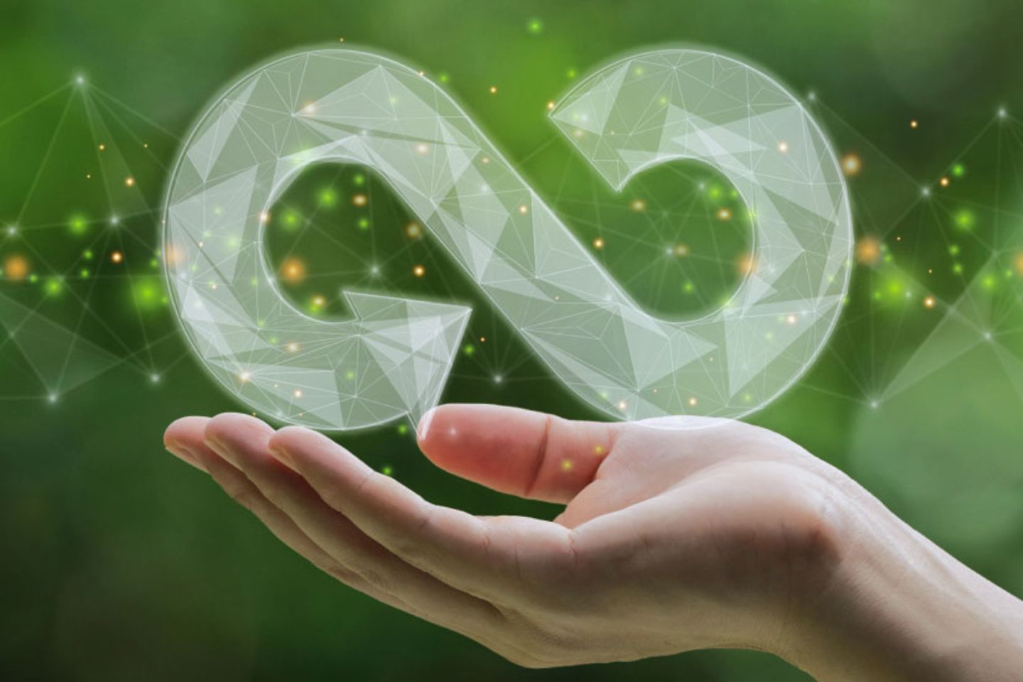 A hand holds an infinity symbol against a green background