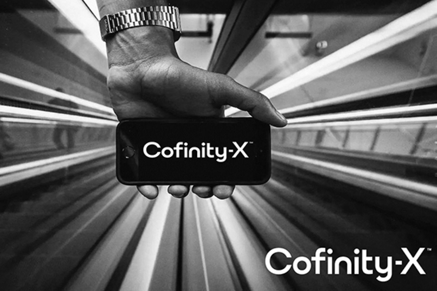 Een hand die een smartphone met het logo van Cofinity-X vasthoudt