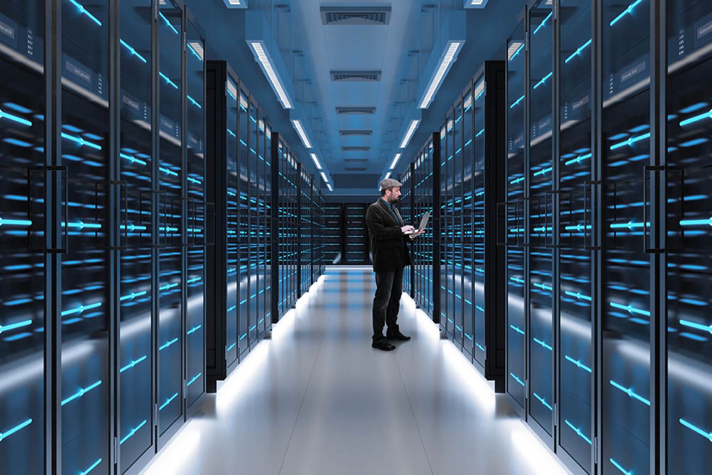 Man working on laptop in server room