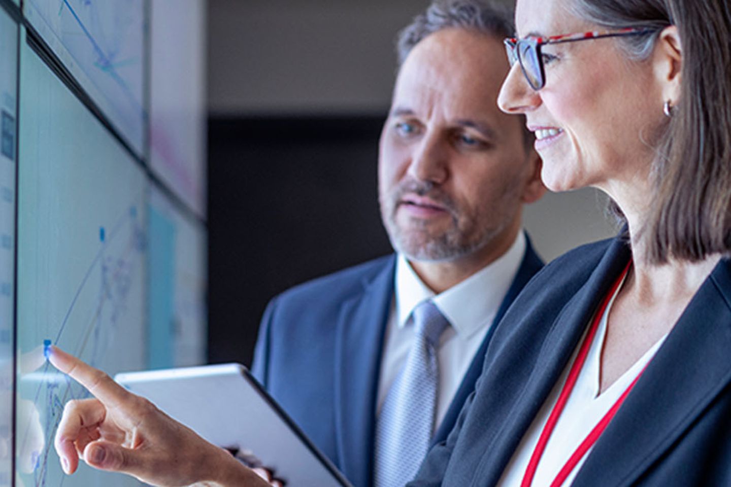 Business people working with charts on interactive screens