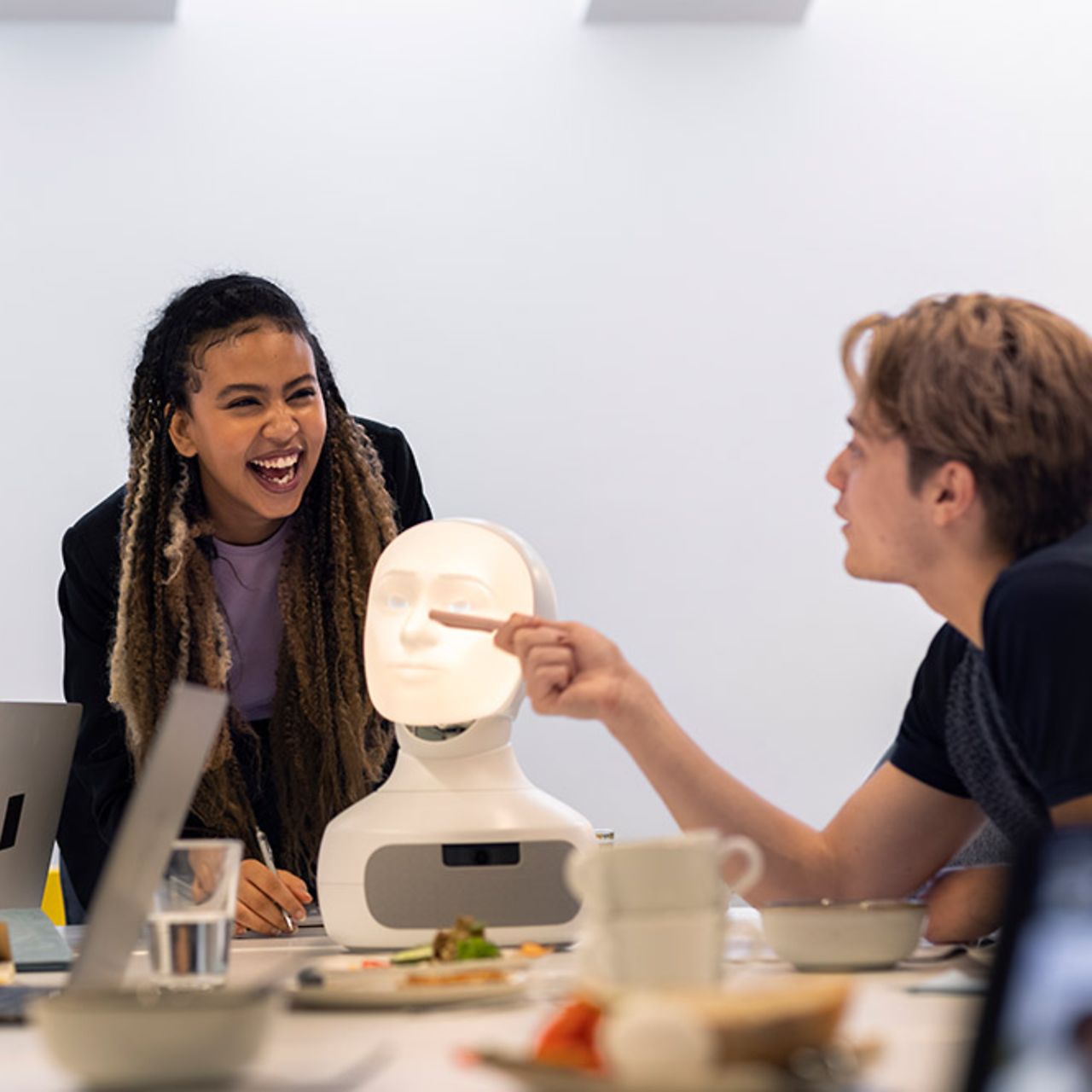 Business people discussing robot voice assistant during meeting