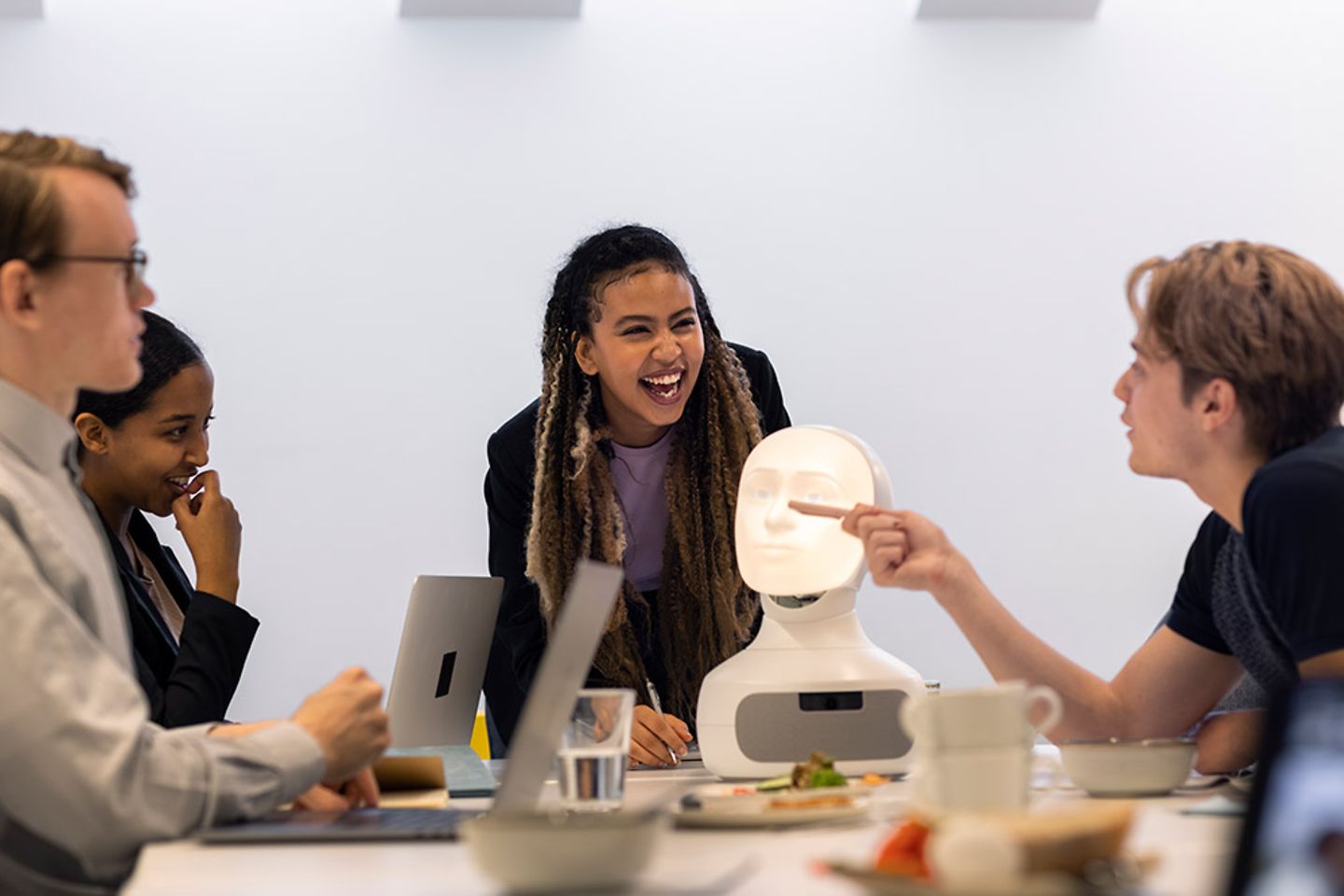 Business people discussing robot voice assistant during meeting