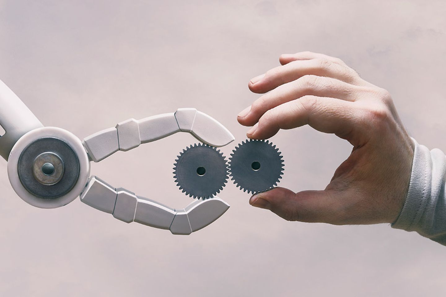 Roboter und menschliche Hand mit Zahnraedern