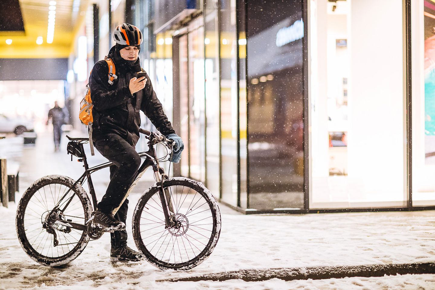 Mann auf Fahrrad hält auf Straße an, um sein Smartphone zu checken