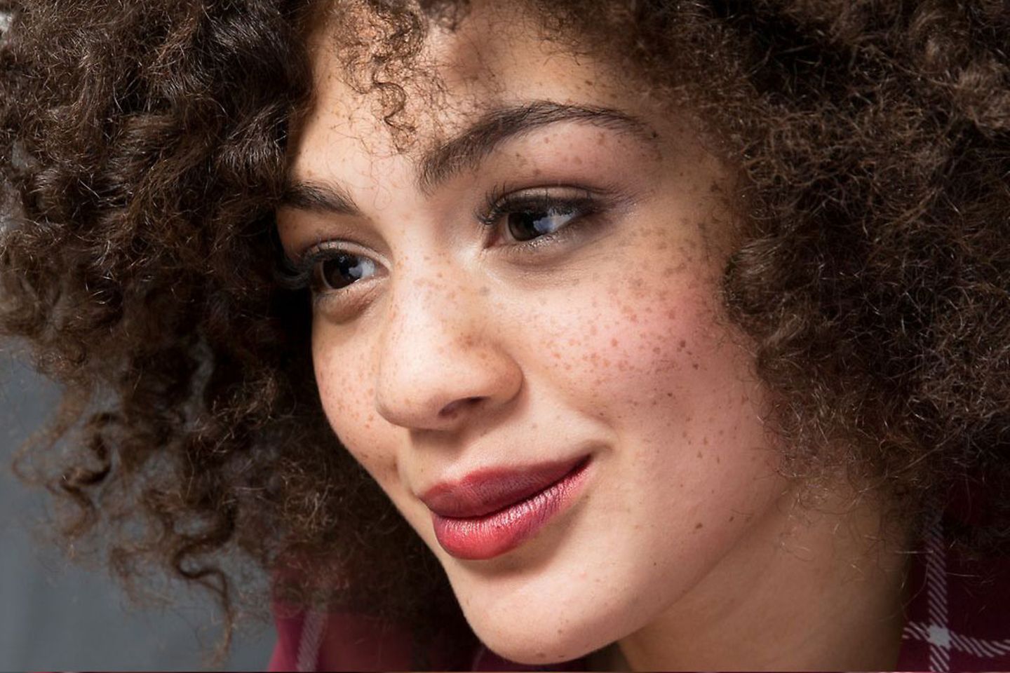 A woman looks at a computer with a smile.