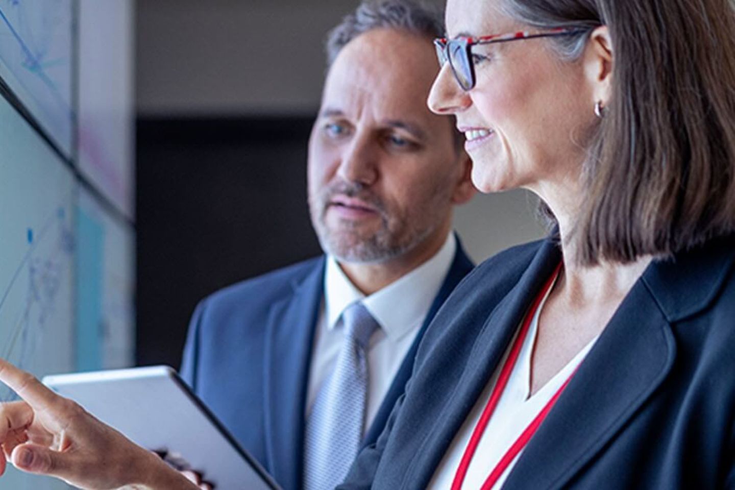 Business people working with charts on interactive screens