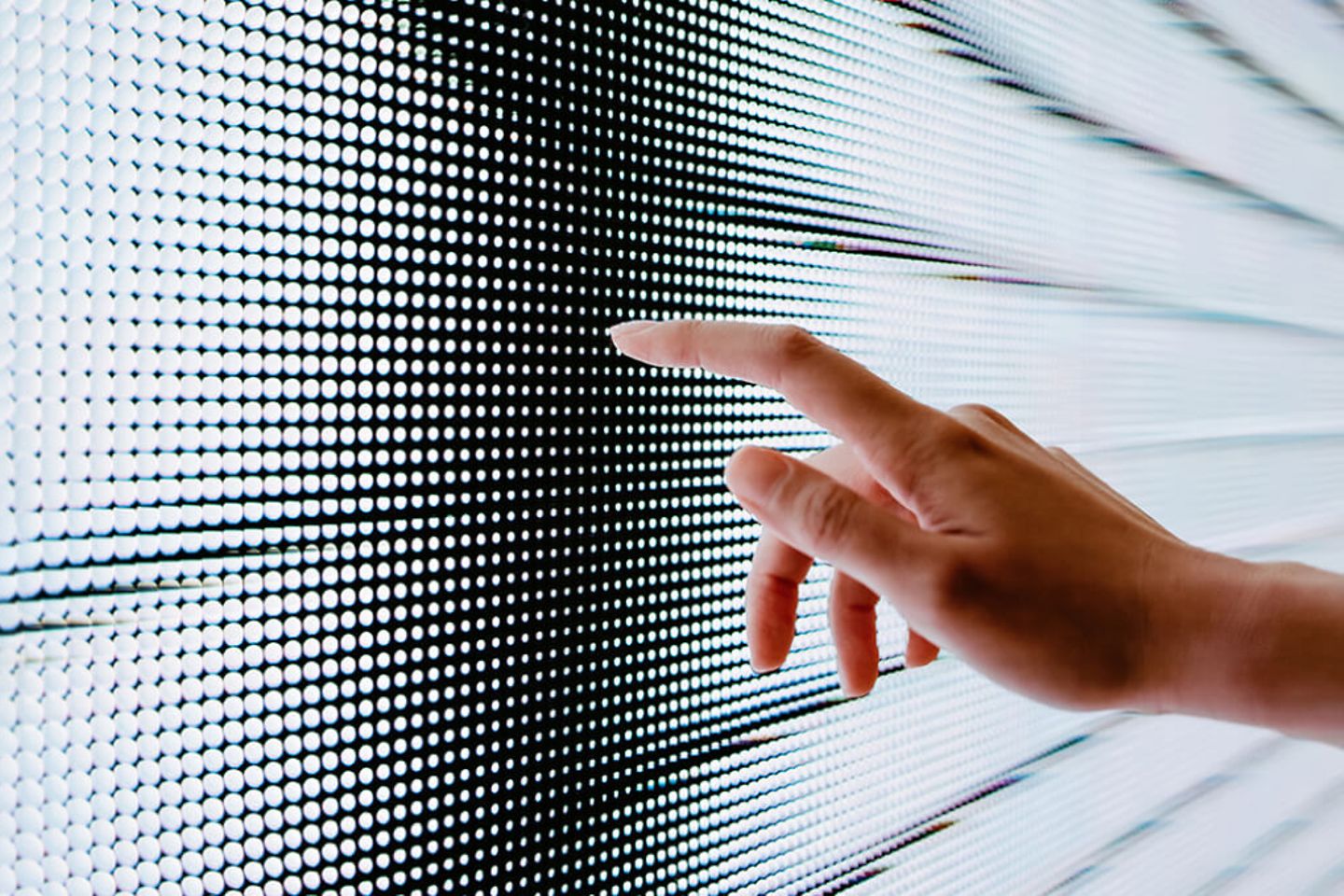 Close-up van een vrouwenhand die een verlicht led-scherm aanraakt