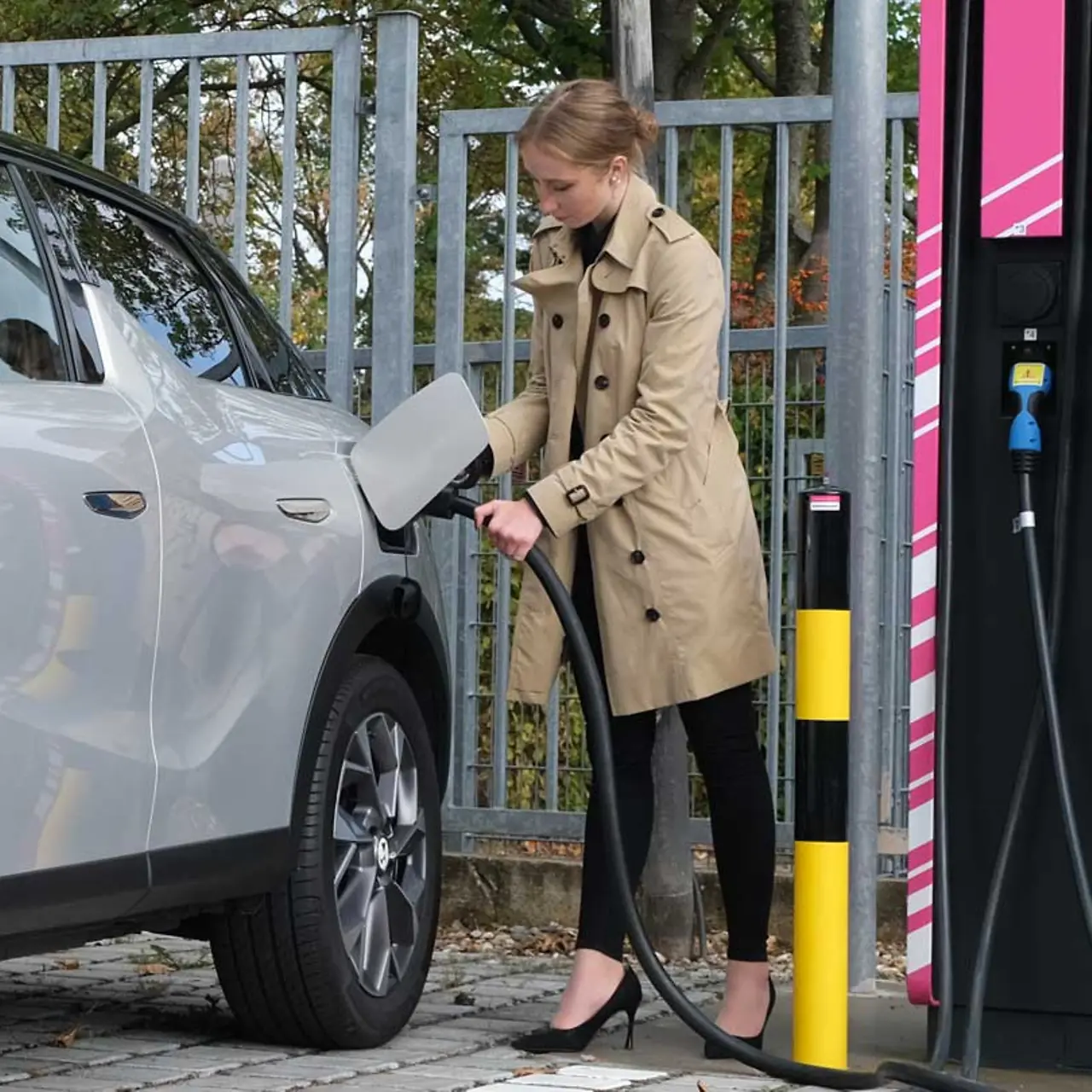 A woman charges her car at a ComfortCharge charging station