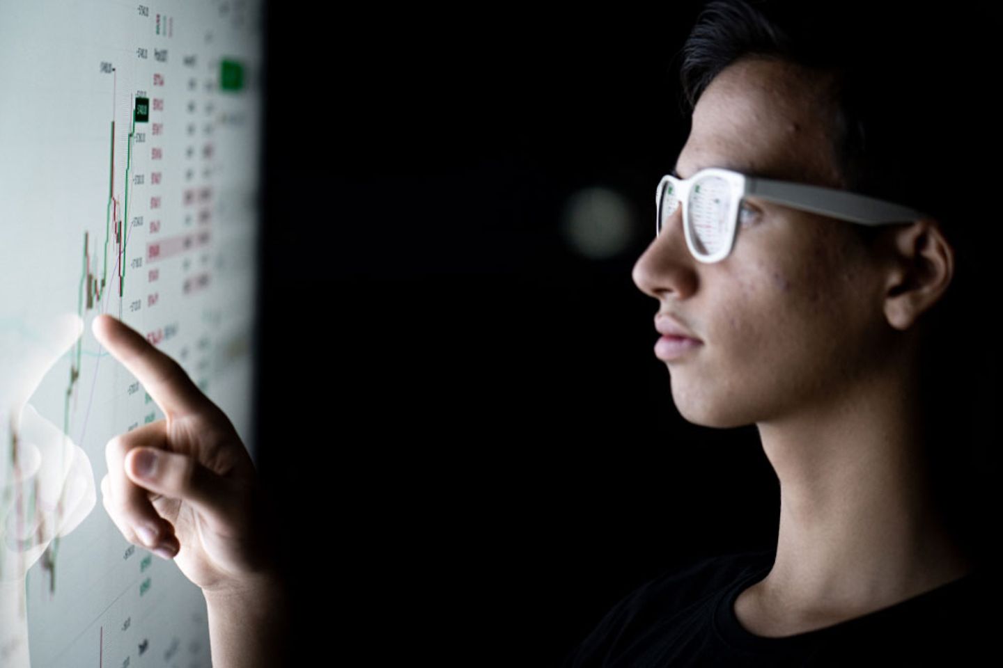 Ein Mann mit Brille zeigt auf ein Diagramm am Bildschirm
