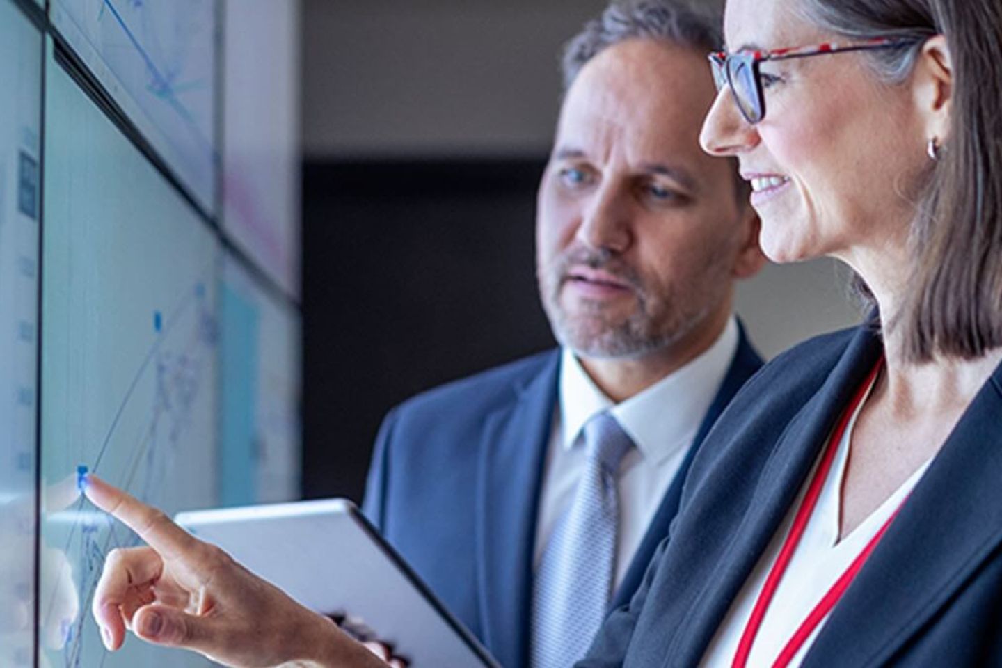 Business people working with charts on interactive screens