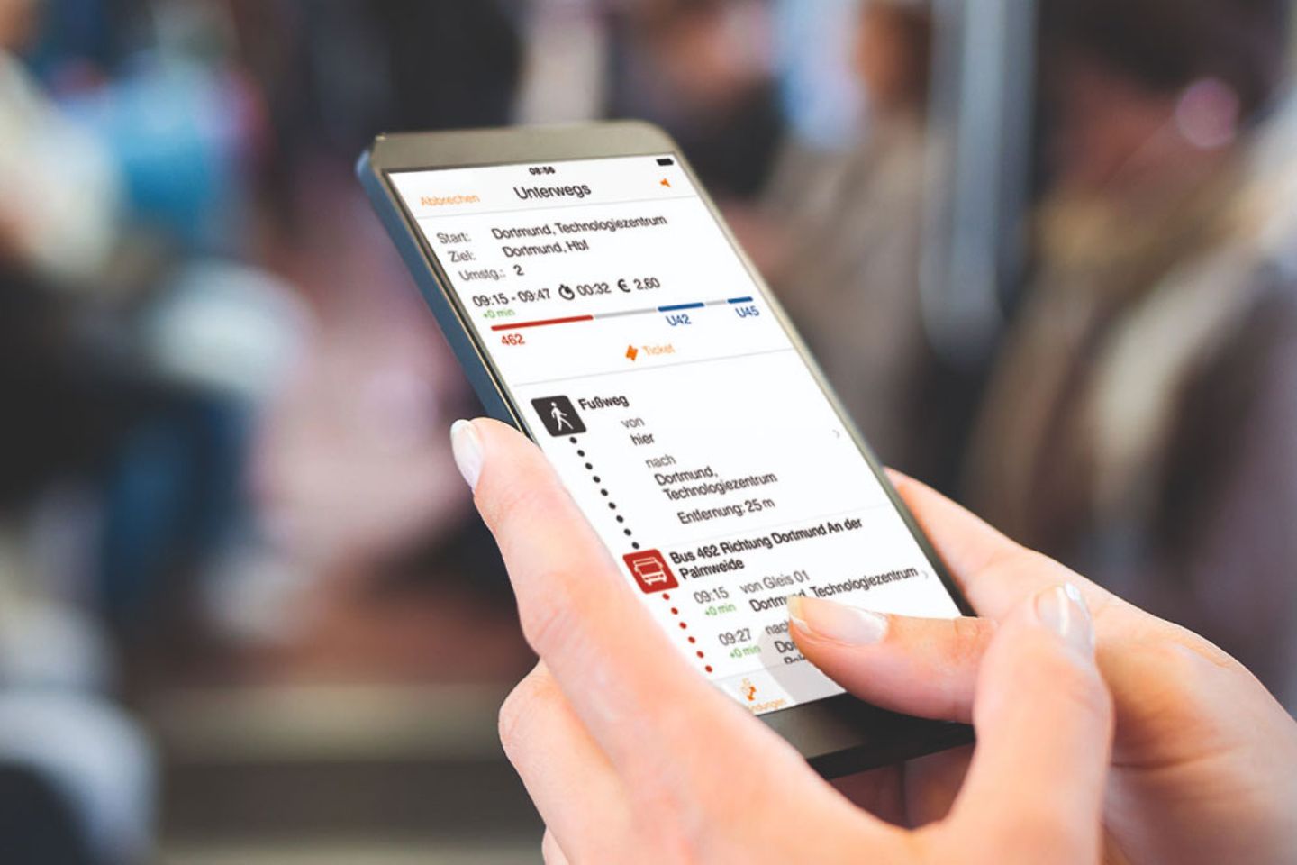 Eine Frau betrachtet ihren persönlichen Fahrplan auf dem Smartphone