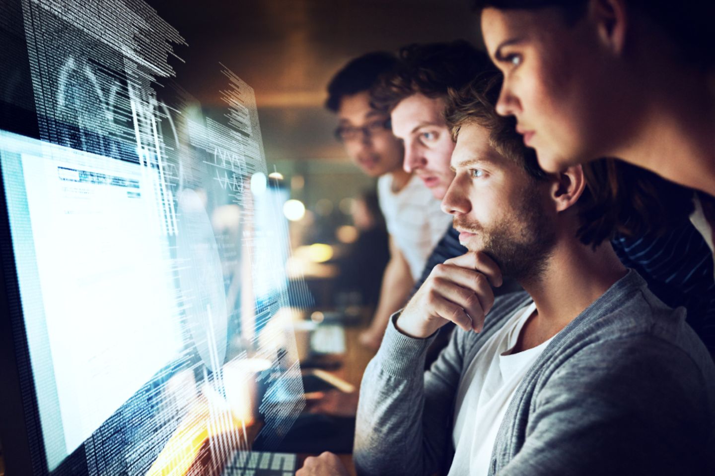 Four People watching at the same computer screen.