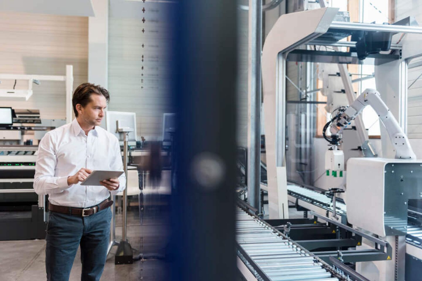 Businessman using tablet at conveyor belt in factory