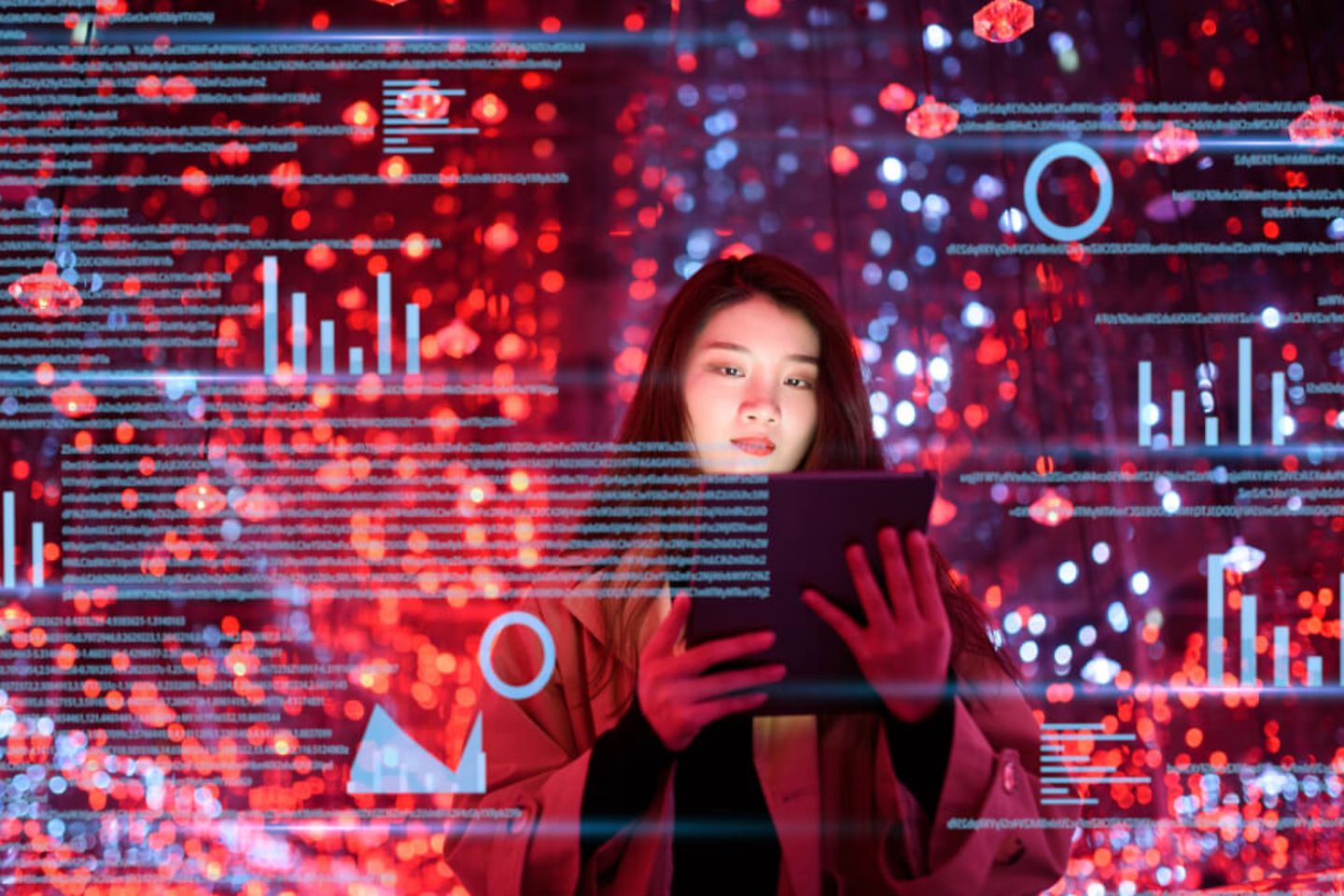 Woman looking at a portable tablet infront of a red background 