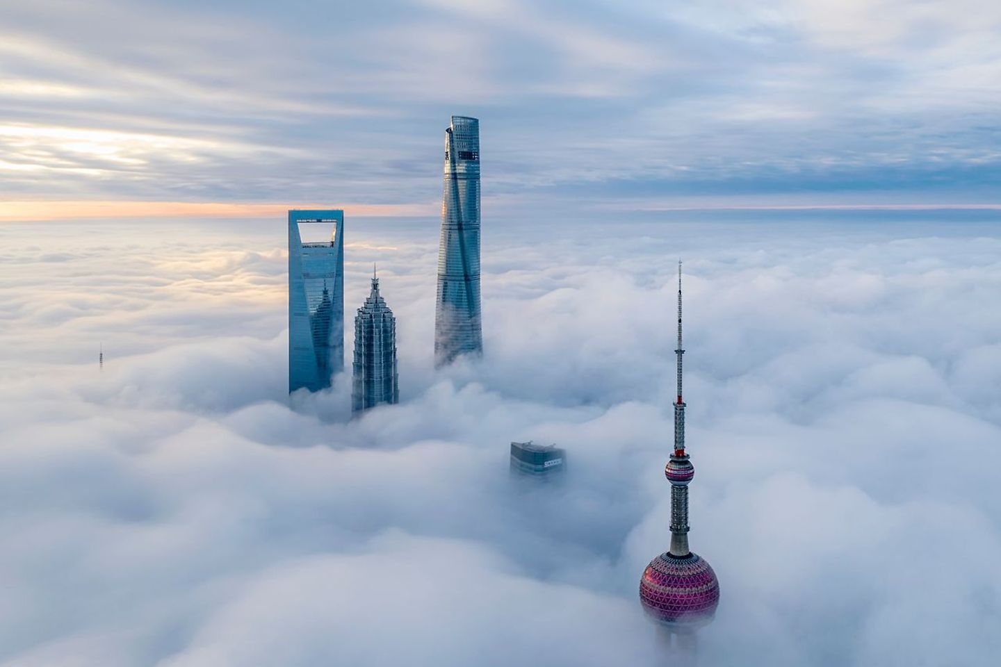 Skyscrapers rise from a thick cloud cover