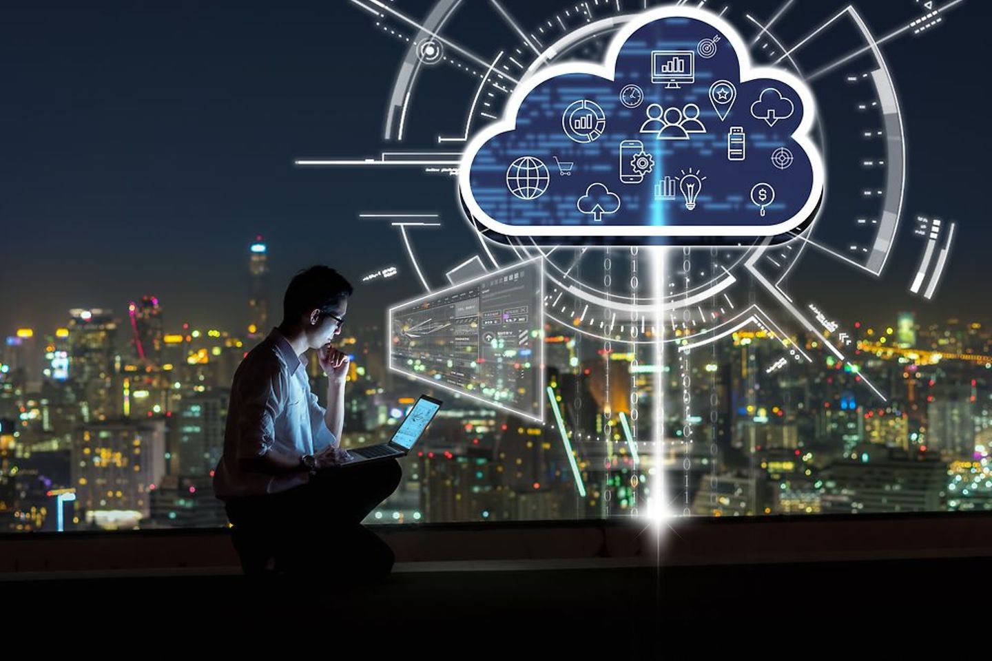 Mann mit Laptop in einer Stadt bei Nacht und Cloud-Symbol