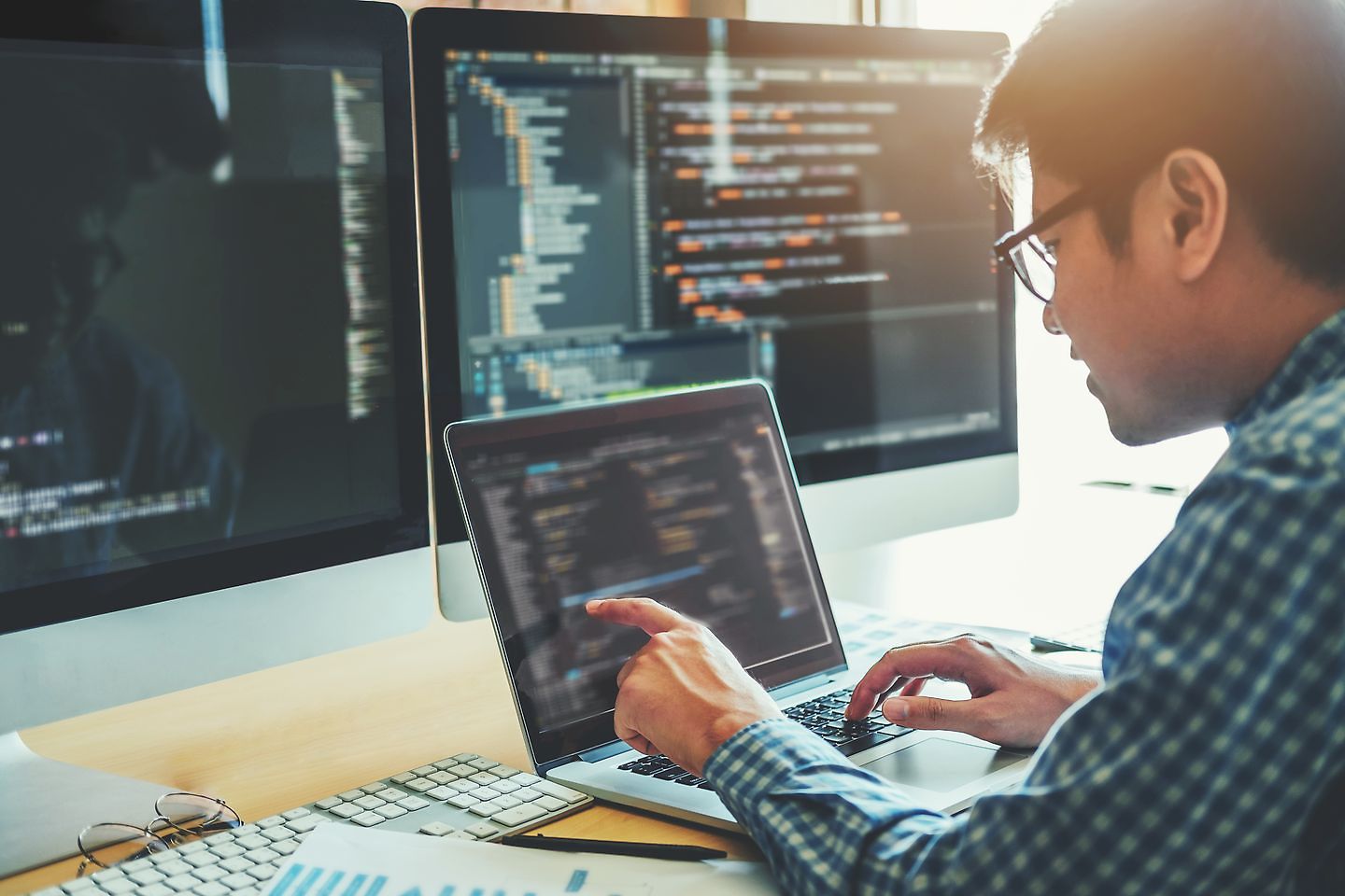 Young man in front of computer with data