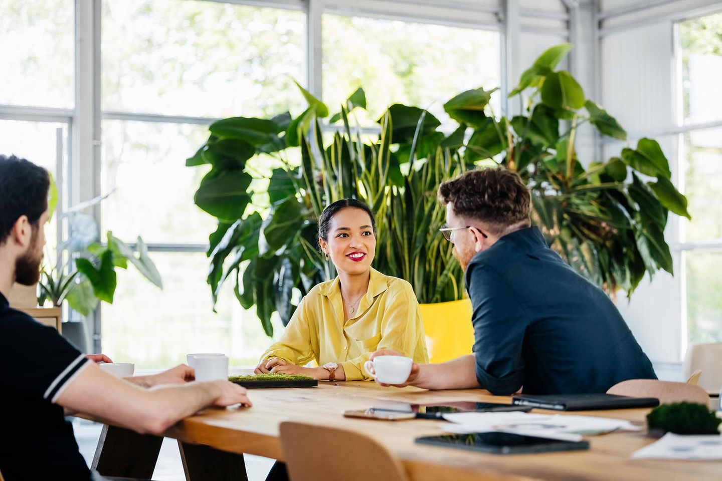 A group of colleagues sitting at a large desk for a business meeting in a modern office space