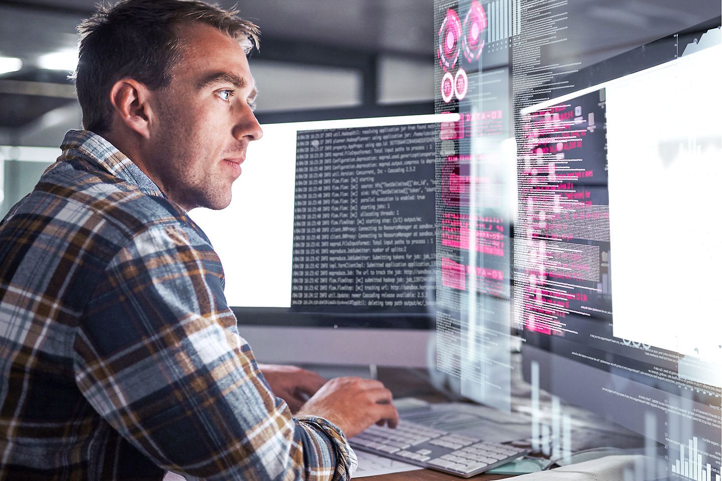 Shot of a young programmer working at his computer with an overlay of computer graphics