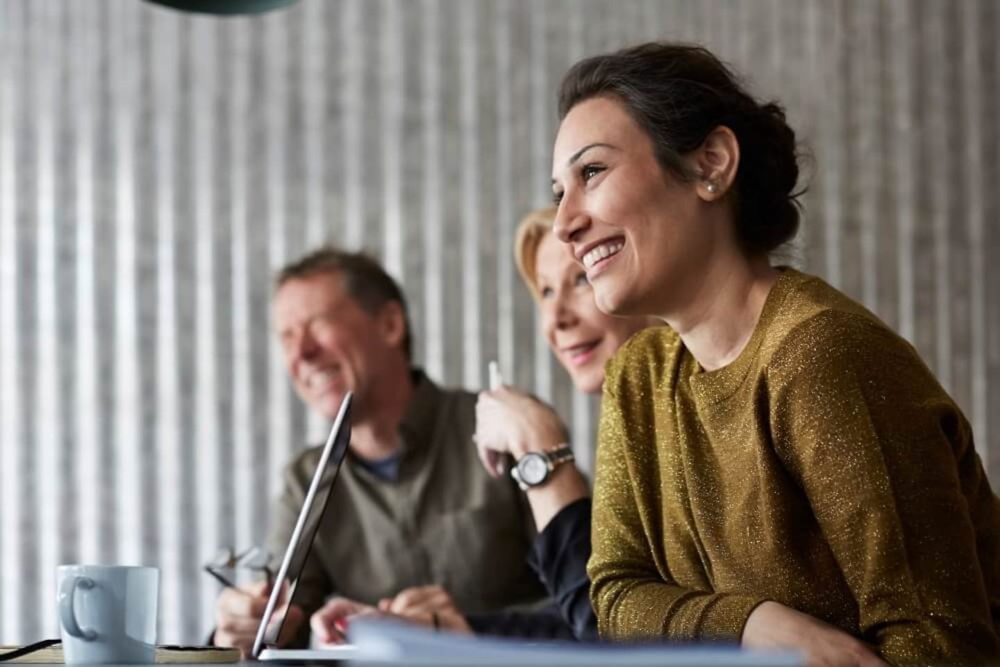 Vier Mitarbeiter diskutieren am Schreibtisch vor einem Bildschirm