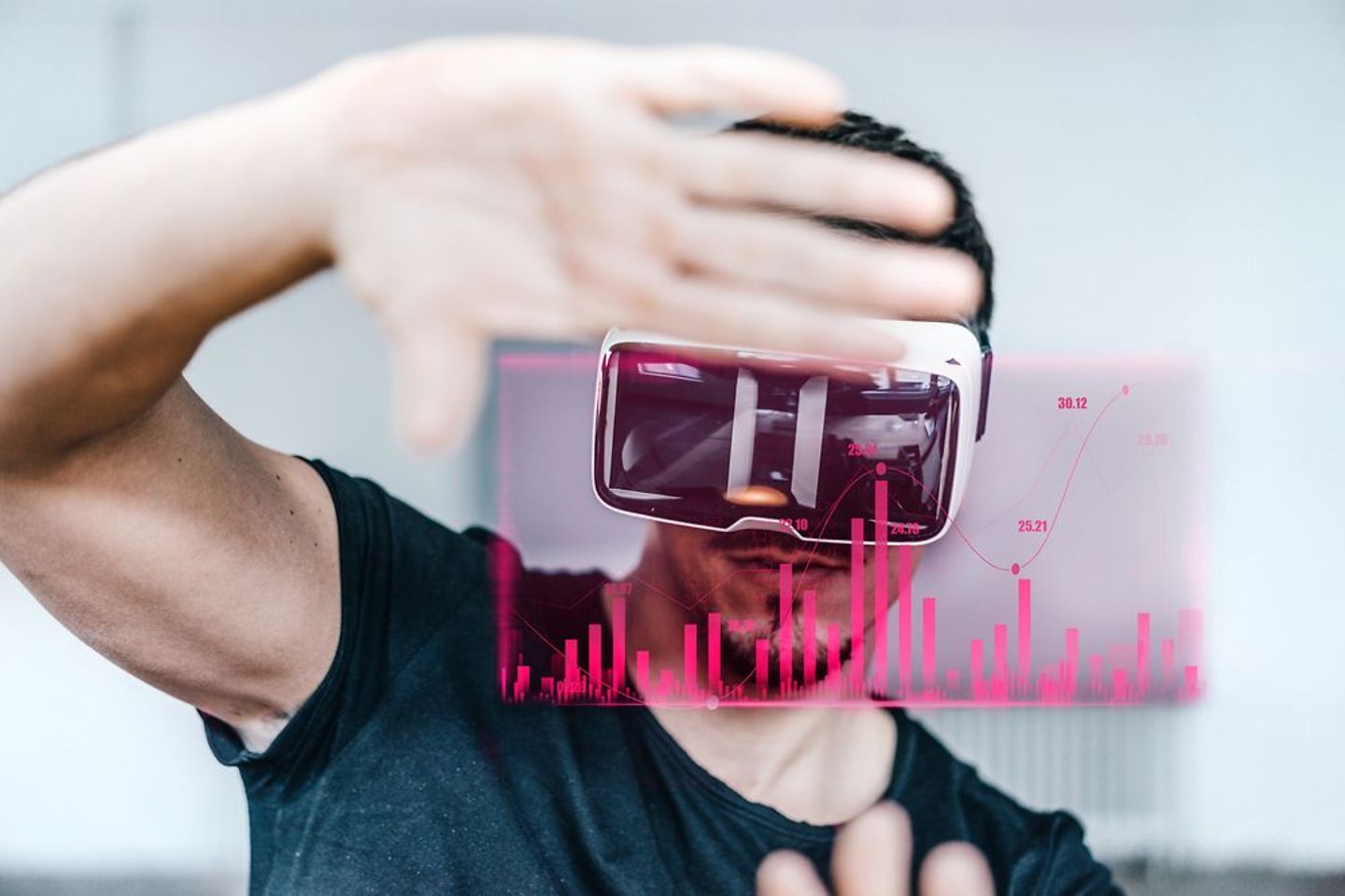 Um homem com óculos de realidade virtual está movendo as suas mãos diante de um gráfico magenta