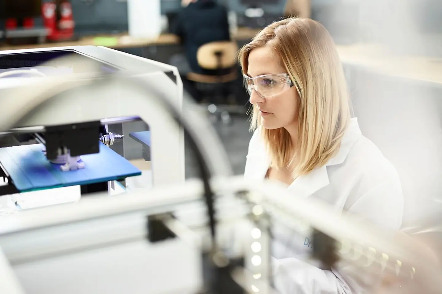 Technikerin prüft 3D-Drucker