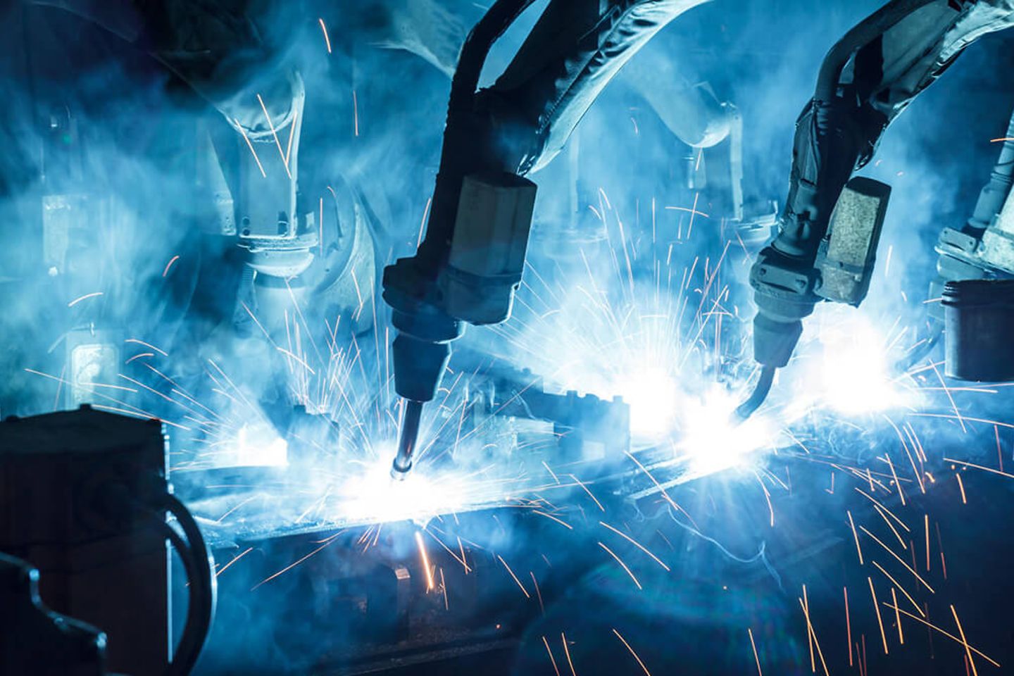 Industrial robots welding on a conveyor belt