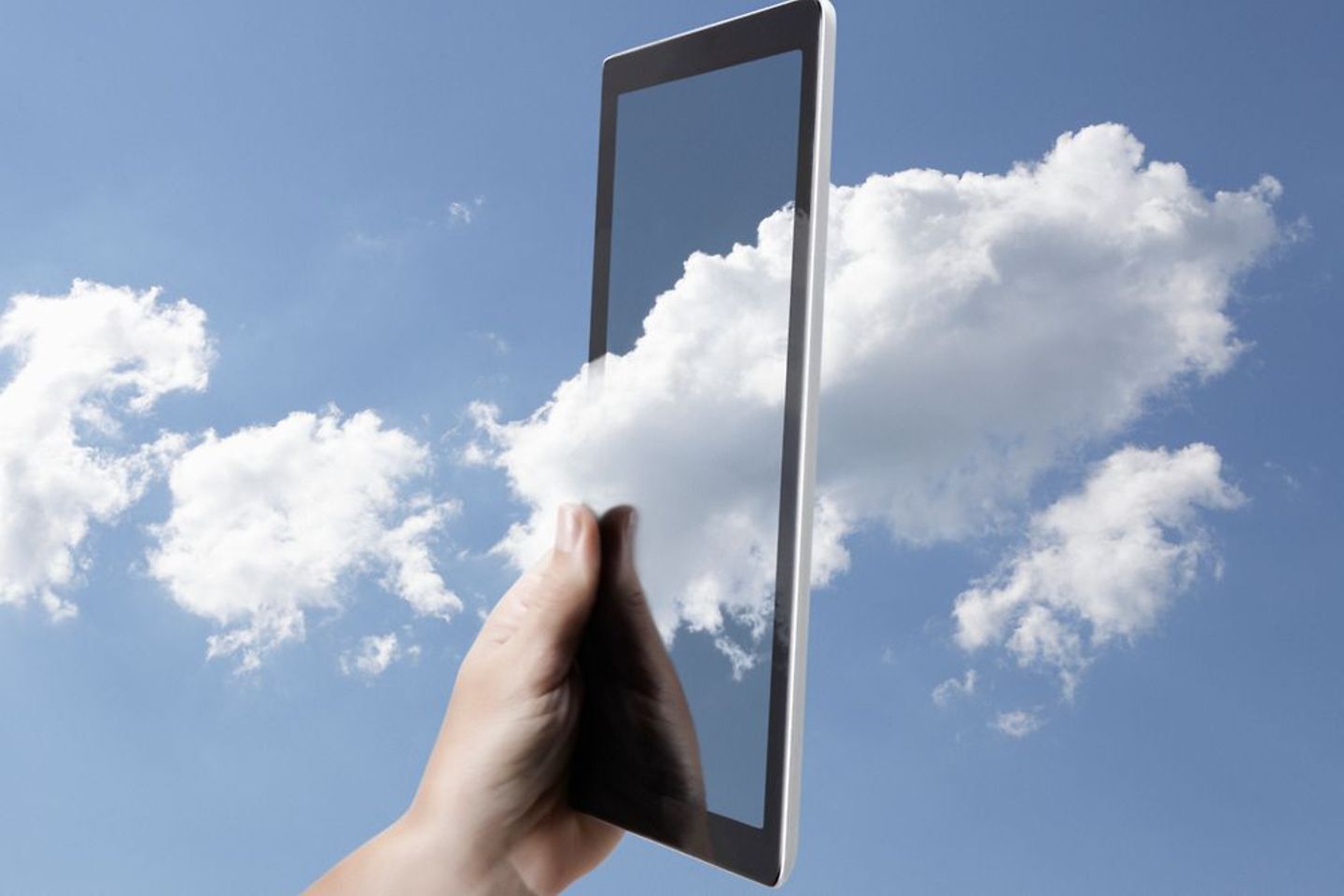 Symbolische weergave van cloud computing met een digitale tabletcomputer in de lucht omgeven door wolken
