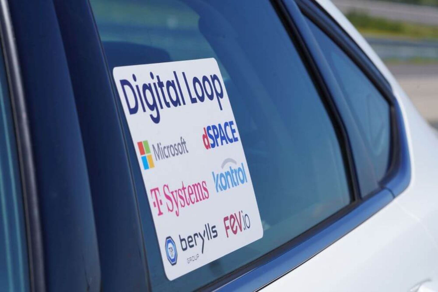 Nahaufnahme von Autoscheibe mit Partnerlogos